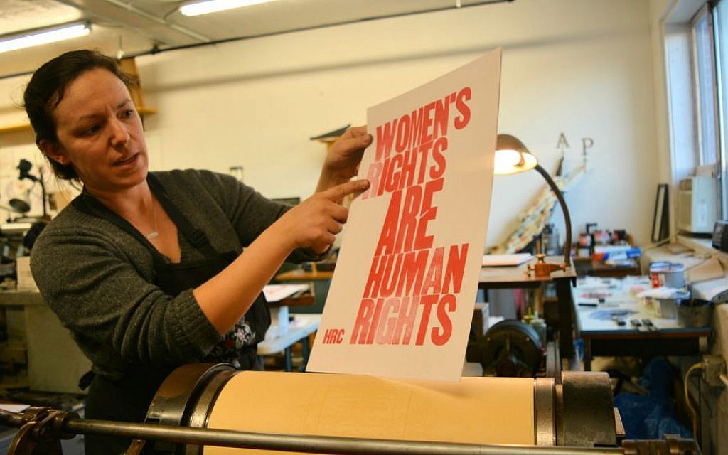 Shelley Barandes examines the poster she is making on an antique letter press for the Women's March on Washington. Barandes, the owner of a design and letterpress print shop in the Boston area, is one of the many American Jews traveling to Washington for the march. (Dina Kraft/Times of Israel) Shelley Barandes examines the poster she is making on an antique letter press for the Women's March on Washington. Barandes, the owner of a design and letterpress print shop in the Boston area, is one of the many American Jews traveling to Washington for the march. (Dina Kraft/Times of Israel)