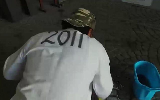 A Bahraini man scrubs the site of a Hanukkah party hosted by the nation's king (screen capture: MEMRI) A Bahraini man scrubs the site of a Hanukkah party hosted by the nation's king (screen capture: MEMRI)