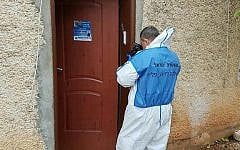 A police investigator takes photographs at the scene of a murder of a woman and three children in the northern town of Migdal on January 28, 2017 (Israel Police)
