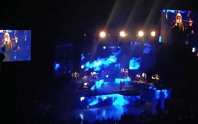 Popular Hasidic singer Mordechai Ben Dovid seen on screens during a concert in Jerusalem, December 29, 2016. (screen capture: YouTube/Yudicom)