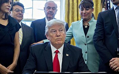 President Donald Trump signing an executive order in the Oval Office of the White House surrounded by small business leaders, Jan. 30, 2017. (Andrew Harrer/Pool/Getty Images)