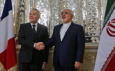 French Foreign Minister Jean-Marc Ayrault (L) and Iranian Foreign Minister Mohammad Javad Zarif shake hands prior to their meeting in Tehran on January 31, 2017. (AFP Photo/Atta Kenare)