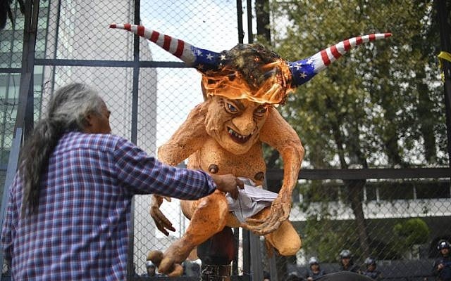 Mexican peasants burn an "Alebrije", traditional Mexican figure, with the face of US President Donald Trump in front of the US embassy building during a protest against the wall between Mexico and the US borders, in Mexico City on January 31, 2017. (AFP / YURI CORTEZ)