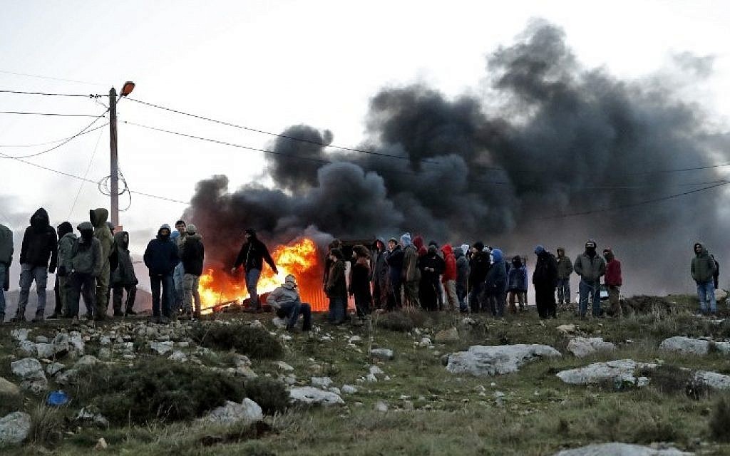 Opponents of the evacuation of the illegal Amona outpost set tires ablaze at Amona, northeast of Ramallah, on February 1, 2017. (AFP Photo/Jack Guez) Opponents of the evacuation of the illegal Amona outpost set tires ablaze at Amona, northeast of Ramallah, on February 1, 2017. (AFP Photo/Jack Guez)