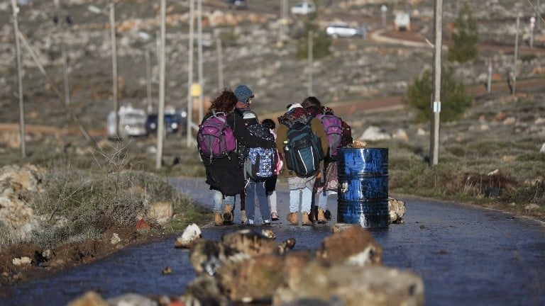 Jewish settlers walk with backpacks at the Amona outpost, northeast of Ramallah, on February 1, 2017. (AFP Photo/Thomas Coex) Jewish settlers walk with backpacks at the Amona outpost, northeast of Ramallah, on February 1, 2017. (AFP Photo/Thomas Coex)