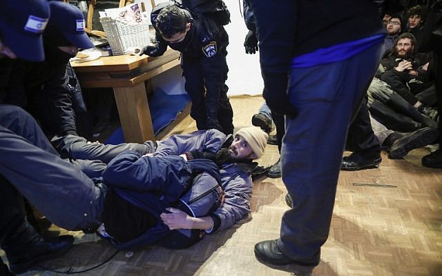 Two settlers lie on the floor as Israeli security forces evict hardline residents from the wildcat Amona outpost, northeast of Ramallah, on February 1, 2017, in line with a High Court ruling that determined the homes were built on privately owned Palestinian land. (AFP/Thomas Coex)