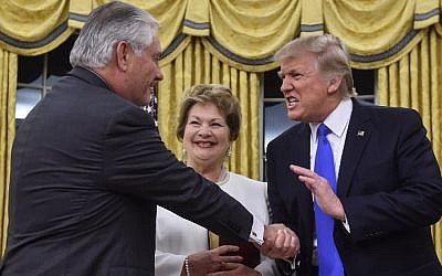 US President Donald Trump (R) shakes hands with Rex Tillerson (L) as Tillerson's wife Renda St. Clair looks on after Tillerson was sworn in as Secretary of State in the Oval Office at the White House in Washington, DC, on February 1, 2017. (AFP Photo/Nicholas Kamm)