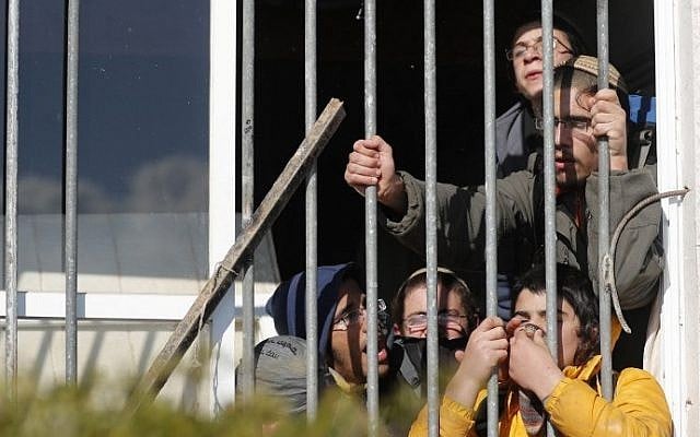 Israeli settlers barricade themselves inside a building on the second day of an Israeli police operation to evacuate the illegal Amona outpost on February 2, 2017. (AFP Photo/Thomas Coex) Israeli settlers barricade themselves inside a building on the second day of an Israeli police operation to evacuate the illegal Amona outpost on February 2, 2017. (AFP Photo/Thomas Coex)