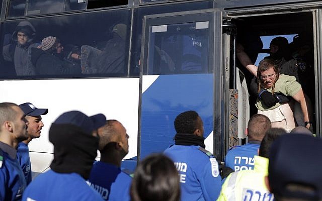 Israeli police drag an Israeli settler onto a bus after being evicted from the West Bank settler outpost of Amona on the second day of an Israeli police operation to remove them from the outpost on February 2, 2017 ( AFP PHOTO / Thomas COEX)