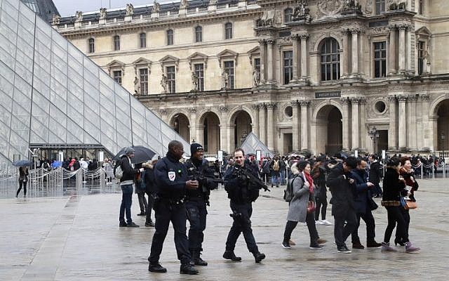 Police officers patrol in front of the Louvre Pyramid in Paris on February 4, 2017 a day after a machete-wielding attacker lunged at four French soldiers in a public area that leads to one of the Louvre Museum's entrances. (AFP PHOTO/JACQUES DEMARTHON)