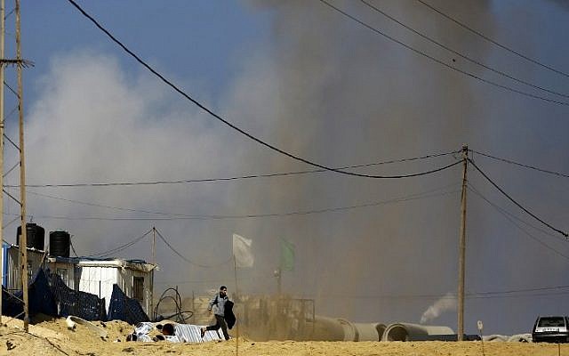 A Palestinian man runs for cover as smoke rises following an Israeli airstrike on a Hamas post in the northern Gaza Strip, February 6, 2017. (AFP/Mohammed Abed) A Palestinian man runs for cover as smoke rises following an Israeli airstrike on a Hamas post in the northern Gaza Strip, February 6, 2017. (AFP/Mohammed Abed)