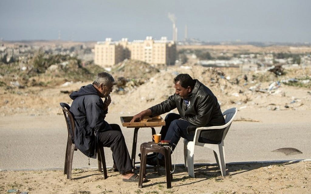 Palestinian men play backgammon next their home in northern Gaza on February 6, 2017, amid a wave of IDF airstrikes on Hamas positions after a rocket was fired at Ashkelon from the Strip (AFP PHOTO/MAHMUD HAMS) Palestinian men play backgammon next their home in northern Gaza on February 6, 2017, amid a wave of IDF airstrikes on Hamas positions after a rocket was fired at Ashkelon from the Strip (AFP PHOTO/MAHMUD HAMS)
