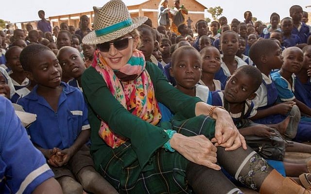 This file photo taken on November 30, 2014 shows US popstar Madonna sitting among Malawian children in the Kasungu District, Central Malawi. (AFP/Amos Gumulira) This file photo taken on November 30, 2014 shows US popstar Madonna sitting among Malawian children in the Kasungu District, Central Malawi. (AFP/Amos Gumulira)