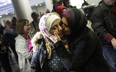 Syrian refugee Baraa Haj Khalaf (L), receives a kiss from her mother Fattoum Haj Khalaf as she arrives at O'Hare International Airport on February 7, 2017 in Chicago, Illinois. (AFP/Joshua Lott)