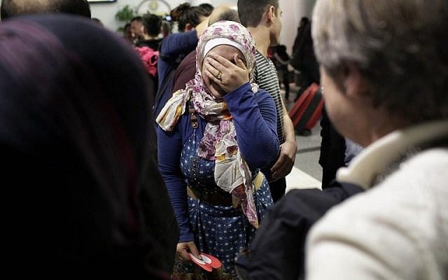 After she and her family were previously banned from entering the United States due to an executive order signed by US President Donald Trump, Syrian refugee Baraa Haj Khalaf, center covers her face as she reacts  to greetings from people during her arrival at O'Hare International Airport, in Chicago, Illinois, February 7, 2017. (AFP/Joshua LOTT)