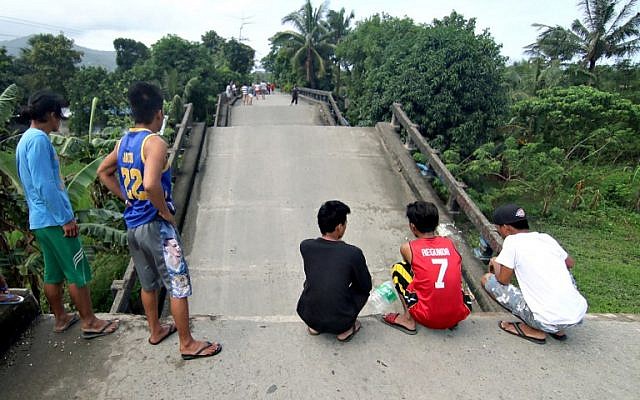 Residents stand on one end of a bridge, linking the city of Surigao to nearby towns, which was damaged after a 6.5-magnitude earthquake struck overnight, in Surigao City in southern island of Mindanao in the Philippines on February 11, 2017. (AFP/Erwin Mascarinas) Residents stand on one end of a bridge, linking the city of Surigao to nearby towns, which was damaged after a 6.5-magnitude earthquake struck overnight, in Surigao City in southern island of Mindanao in the Philippines on February 11, 2017. (AFP/Erwin Mascarinas)