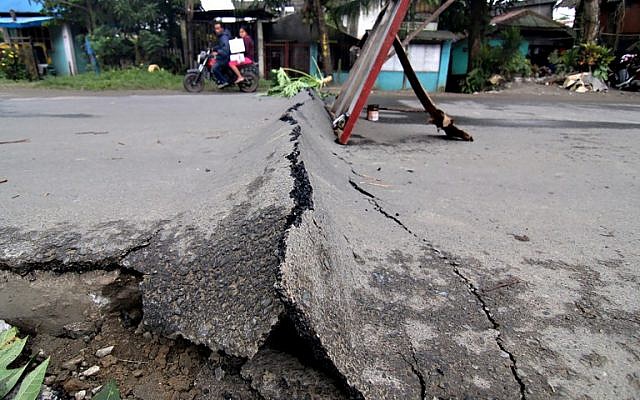 A motorcyclist rides around an asphalt road, which was damaged after a 6.5-magnitude earthquake struck overnight, in Surigao City in southern island of Mindanao in the Philippines on February 11, 2017. (AFP PHOTO / ERWIN MASCARINAS) A motorcyclist rides around an asphalt road, which was damaged after a 6.5-magnitude earthquake struck overnight, in Surigao City in southern island of Mindanao in the Philippines on February 11, 2017. (AFP PHOTO / ERWIN MASCARINAS)