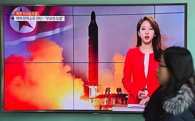 A woman walks past a television screen showing file footage of North Korea's missile launch at a railway station in Seoul, South Korea, February 12, 2017. (AFP/Jung Yeon-Je)