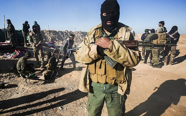 A masked fighter of the Hashed al-Shaabi (Popular Mobilization) paramilitaries poses for a picture carrying a Kalashnikov assault rifle by defensive positions on the outskirts of Tal Afar west of Mosul, where Iraqi forces are preparing for the offensive retake the western side of Mosul from Islamic State (IS) group fighters, on February 18, 2017. ( AFP PHOTO / AHMAD AL-RUBAYE) A masked fighter of the Hashed al-Shaabi (Popular Mobilization) paramilitaries poses for a picture carrying a Kalashnikov assault rifle by defensive positions on the outskirts of Tal Afar west of Mosul, where Iraqi forces are preparing for the offensive retake the western side of Mosul from Islamic State (IS) group fighters, on February 18, 2017. ( AFP PHOTO / AHMAD AL-RUBAYE)