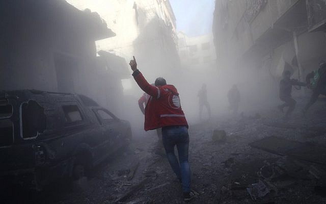 A member of the Syrian Arab Red Crescent runs as he searches for victims following a reported government airstrike on the rebel-held town of Douma, on the eastern outskirts of the capital Damascus, on February 19, 2017. (AFP /Abd Doumany)