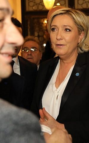 France's far-right presidential candidate Marine Le Pen (R) reacts upon being handed a headscarf ahead of her meeting with Lebanon's Grand Mufti Sheikh Abdul Latif Derian, in the capital Beirut on February 21, 2017. (AFP Photo/Anwar Amro)