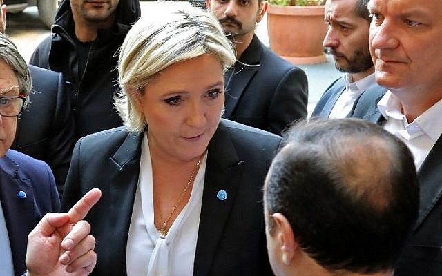 France's far-right presidential candidate Marine Le Pen (C) reacts upon being handed a headscarf ahead of her meeting with Lebanon's Grand Mufti Sheikh Abdul Latif Derian, in the capital Beirut on February 21, 2017. (AFP Photo/Anwar Amro)