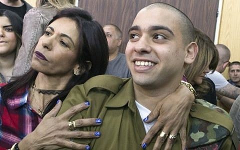 IDF soldier Elor Azaria, right, convicted on the manslaughter of a wounded Palestinian, is embraced by his mother Oshra at the start of his sentencing hearing in a military court in Tel Aviv, February 21, 2017. (AFP/POOL/ JIM HOLLANDER)