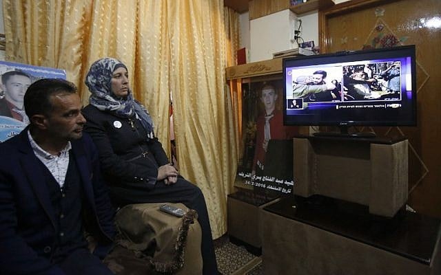 The father and mother of Palestinian attacker Abdul Fatah al-Sharif, who was shot dead as he lay on the ground by IDF soldier Elor Azaria, watch on television the verdict of the trial of the soldier, at their family home in the West Bank city of Hebron, February 21, 2017. (AFP/HAZEM BADER)