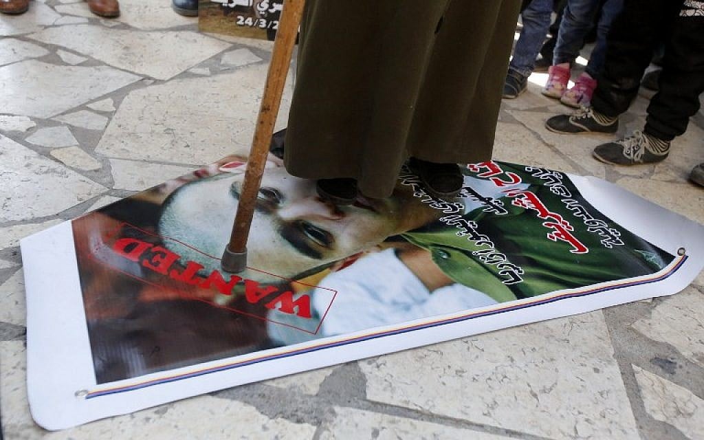 A Palestinian woman steps during a demonstration on a portrait of Israeli soldier Elor Azaria, on February 21, 2017 (AFP PHOTO / HAZEM BADER)
