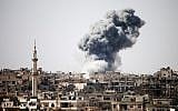 Illustrative. Smoke billows in the distance following reported air strikes on the southern Syrian city of Daraa on February 22, 2017. (Mohamad Abazeed/AFP)