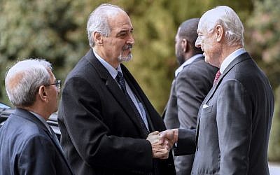 Syrian UN Ambassador Bashar Jaafari (L) shakes hand with UN Syria envoy Staffan de Mistura (R) upon his arrival to take part in the second day of a new round of Syria peace talks, on February 24, 2017 in Geneva. (AFP Photo/Philippe Desmazes)