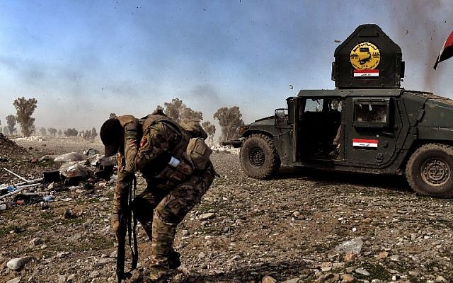 A member of Iraq's elite Rapid Response Division tries to shield himself during an explosion during the assault to retake the northern city of Mosul, as Iraqi forces continue the offensive to retake the city's western half from IS, on February 25, 2017. (AFP/Aris Messinis) A member of Iraq's elite Rapid Response Division tries to shield himself during an explosion during the assault to retake the northern city of Mosul, as Iraqi forces continue the offensive to retake the city's western half from IS, on February 25, 2017. (AFP/Aris Messinis)
