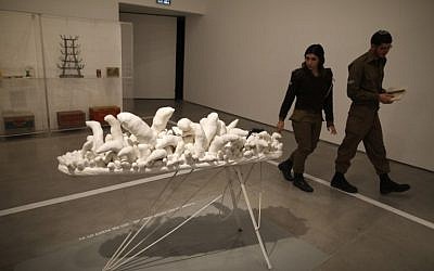 Israeli soldiers walk past the "Untitled (Ironing Board)" installation by artist Yayoi Kusama at the utility room section of the No Place Like Home exhibition, in the Israel Museum in Jerusalem, on February 26, 2017. (AFP PHOTO / MENAHEM KAHANA)