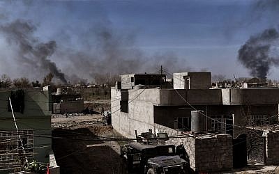 A view of the city of Mosul shows smoke billowing while Iraqi forces fight jihadists as they advance in the city on February 26, 2017, during an operation to retake the city from Islamic State (IS) group fighters. (Aris Messinis/AFP) 