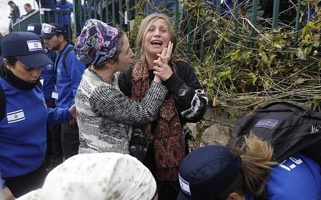 Police evacuate a protester from the West Bank settlement of Ofra on February 28, 2017. (AFP/ MENAHEM KAHANA)