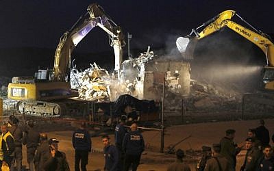 Diggers under the supervision of Israeli forces destroy a house in the Jewish settlement of Ofra in the West Bank, on February 28, 2017. (AFP Photo/Menahem Kahana)