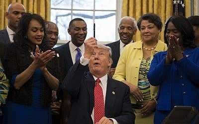 US President Donald Trump (C) holds up a pen after signing an executive order in the Oval Office of the White House in Washington, DC, February 28, 2017. (AFP Photo/Jim Watson)