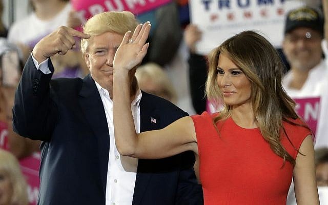 President Donald Trump points to his wife, first lady Melania Trump, during a campaign rally Saturday, Feb. 18, 2017, at Orlando-Melbourne International Airport, in Melbourne, Fla. (AP Photo/Chris O'Meara)