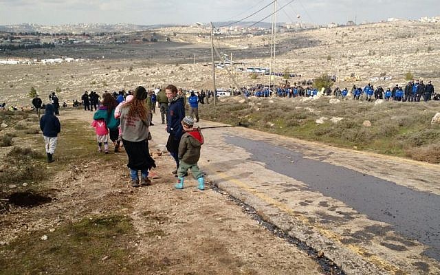 Amona parents sending their kids down the hill ahead of the evacuation, February 1, 2017 (Judah Ari Gross/Times of Israel)