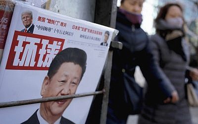 Women walk past a news stand displaying a Chinese news magazine fronting a photo of Chinese President Xi Jinping and US President Donald Trump, in Beijing, February 9, 2017. (AP/Andy Wong)