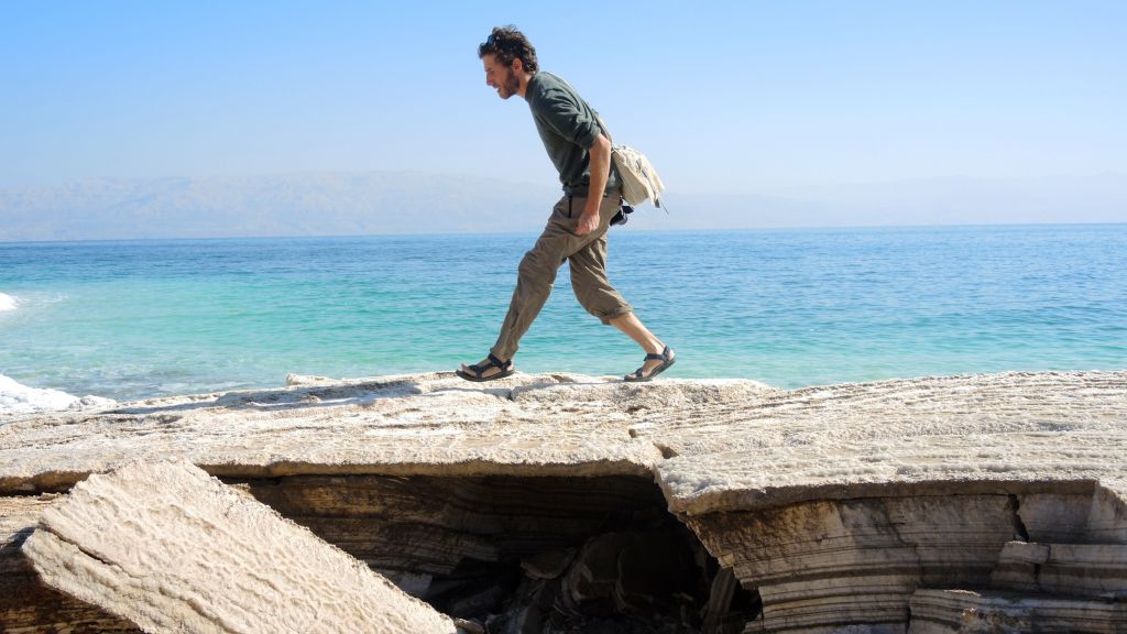Geologist Ariel Meroz tiptoes over a thin crust covering a sinkhole on January 11, 2017. (Melanie Lidman/Times of Israel)