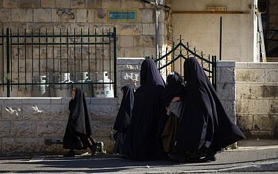 Ultra-Orthodox women and children wear full covering as a means of modesty, as they walk through the neighborhood of Meah Shearim in Jerusalem on April 5, 2015 (Nati Shohat/Flash 90)