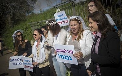 Activists, among them Zionist Union MK Ksenia Svetlova (second from right), holding signs and wearing wedding veils as they protest for the right to civil marriage in front of the Knesset in Jeruslaem on November 2, 2016. (Yonatan Sindel/Flash90)