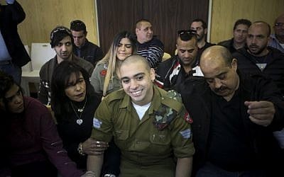 IDF soldier Elor Azaria, who was convicted of manslaughter for shooting dead a prone and wounded Palestinian assailant, in a case that has deeply divided Israel, sits with his parents during sentence hearing at a military court in Tel Aviv on January 24, 2017. (Flash90)
