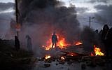 Protesters burn tires at the entrance to the illegal outpost of Amona, on February 1, 2017. Residents of the West Bank outpost of Amona have been given 48 hours to leave the hilltop community ahead of its court-ordered demolition. (Hadas Parush/Flash90)
