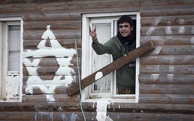 A man screaming at police (unseen) from a house during the evacuation of the illegal outpost of Amona, on February 1, 2017. (Miriam Alster/Flash90) 