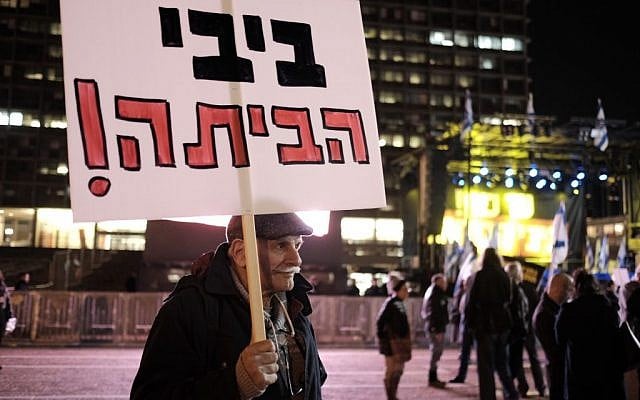 An Israeli carrying a sign that says "Bibi go home" takes part in a protest against Prime Minister Benjamin Netanyahu in Tel Aviv, on February 2, 2017. (Tomer Neuberg/Flash90)
