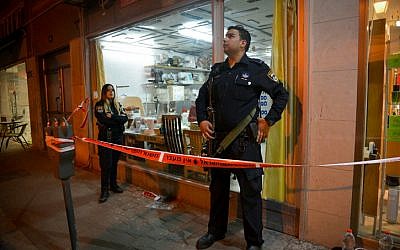 Police stand guard outside a sewing machine shop where a Palestinian man was captured after he opened fire at a bus outside the Petah Tikva central market on February 9, 2017. Five people were injured in the attack. (Flash90) Police stand guard outside a sewing machine shop where a Palestinian man was captured after he opened fire at a bus outside the Petah Tikva central market on February 9, 2017. Five people were injured in the attack. (Flash90)