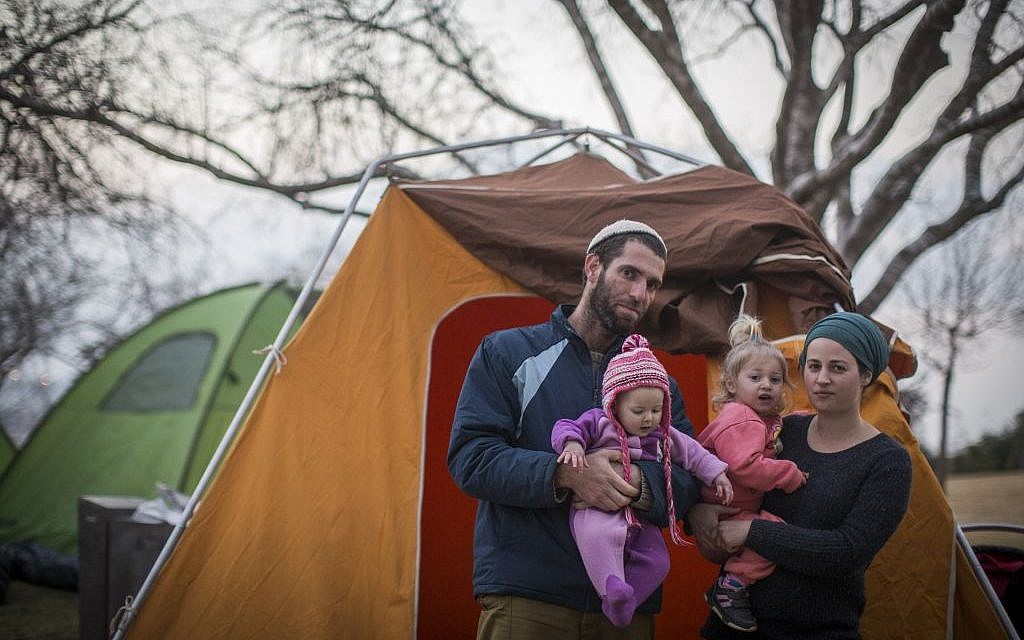 Tova and Neria Antman with their daughters pose for a photo by the tents set up as part of a protest of the Amona evacuation opposite the Israeli parliament on February 9, 2017. (Hadas Parush/Flash90)