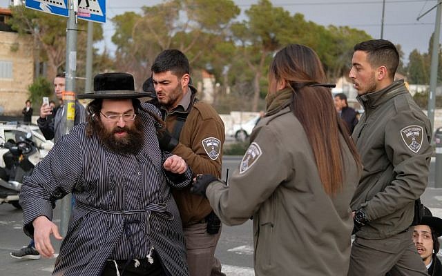 Police officers clash with ultra-Orthodox Jewish men during a protest against the jailing of a yeshiva student who failed to comply with a recruitment order, near the entrance to Route 1 in Jerusalem on February 9, 2017. (Photo by Yaniv Nadav/Flash90)